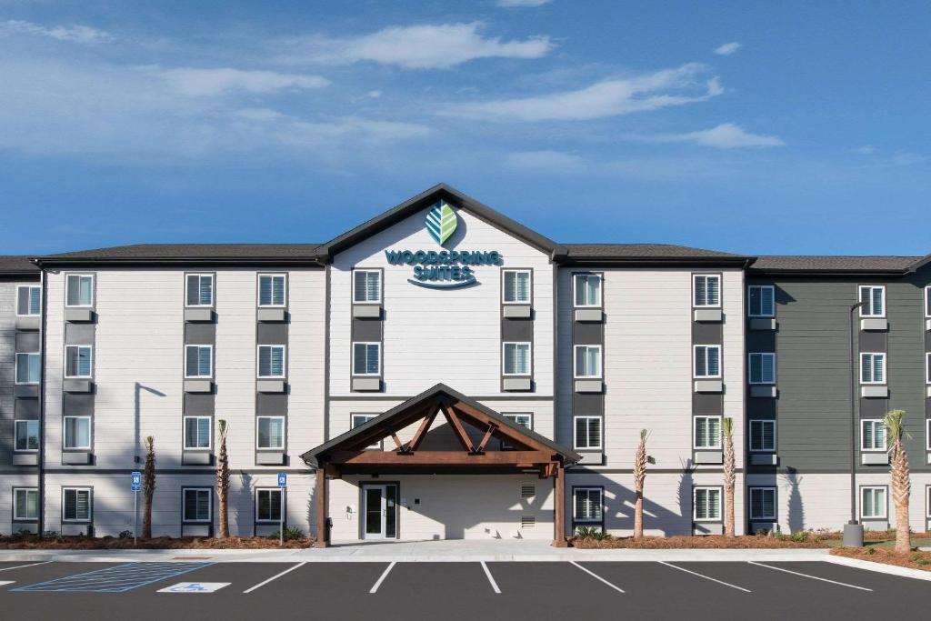 un hôtel avec un parking dans l'établissement WoodSpring Suites Savannah Pooler, à Savannah