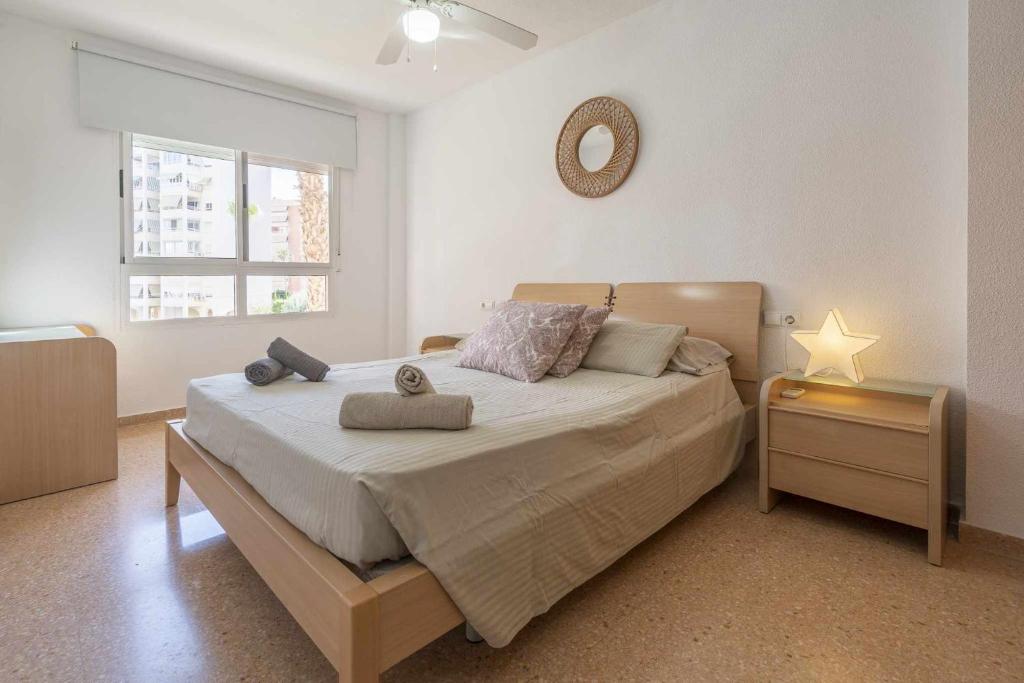 a bedroom with a bed and a mirror on the wall at Urbanización Bulevar Playa in Benimagrell
