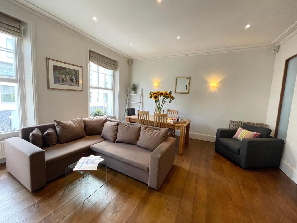 een woonkamer met een bank en een stoel bij Victoria Maisonette Apartment in Londen