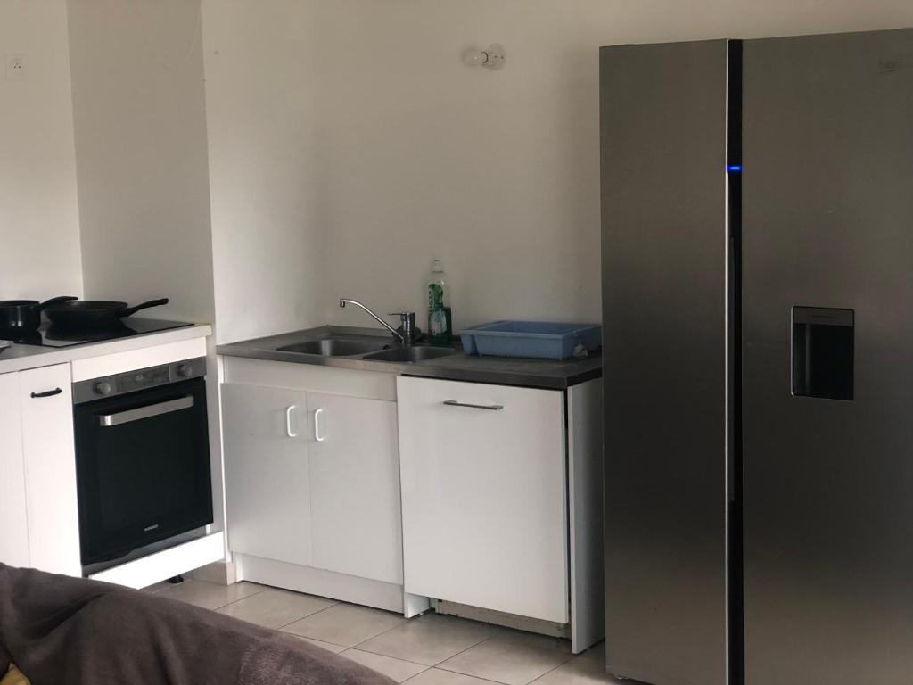 a small kitchen with a sink and a refrigerator at Jolie chambre à Nanterre Préfecture proche La Défense Aréna Campus SNCF et Paris in Nanterre