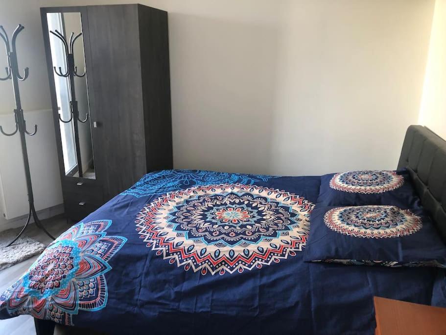 a bed with a blue comforter with two pillows on it at Jolie chambre à Nanterre Préfecture proche La Défense Aréna Campus SNCF et Paris in Nanterre