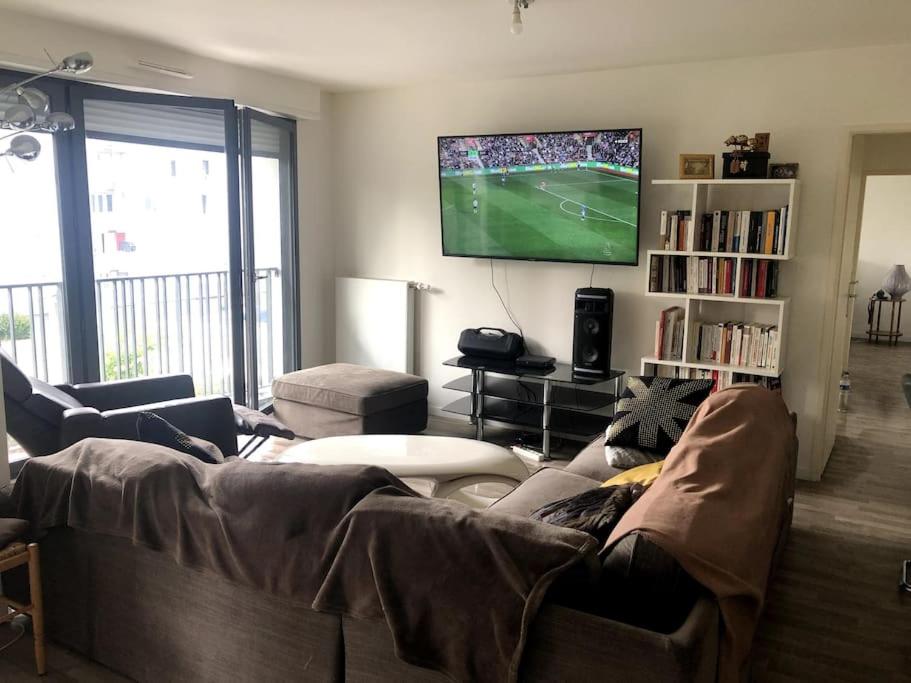 a living room with a couch and a flat screen tv at Jolie chambre à Nanterre Préfecture proche La Défense Aréna Campus SNCF et Paris in Nanterre