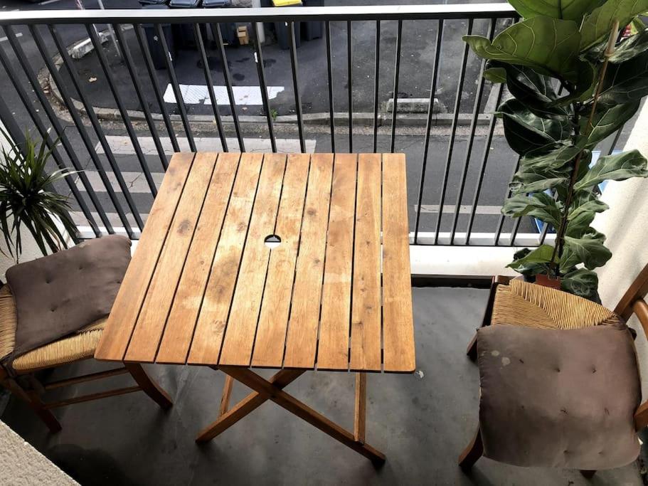 a wooden table and two chairs on a balcony at Jolie chambre à Nanterre Préfecture proche La Défense Aréna Campus SNCF et Paris in Nanterre