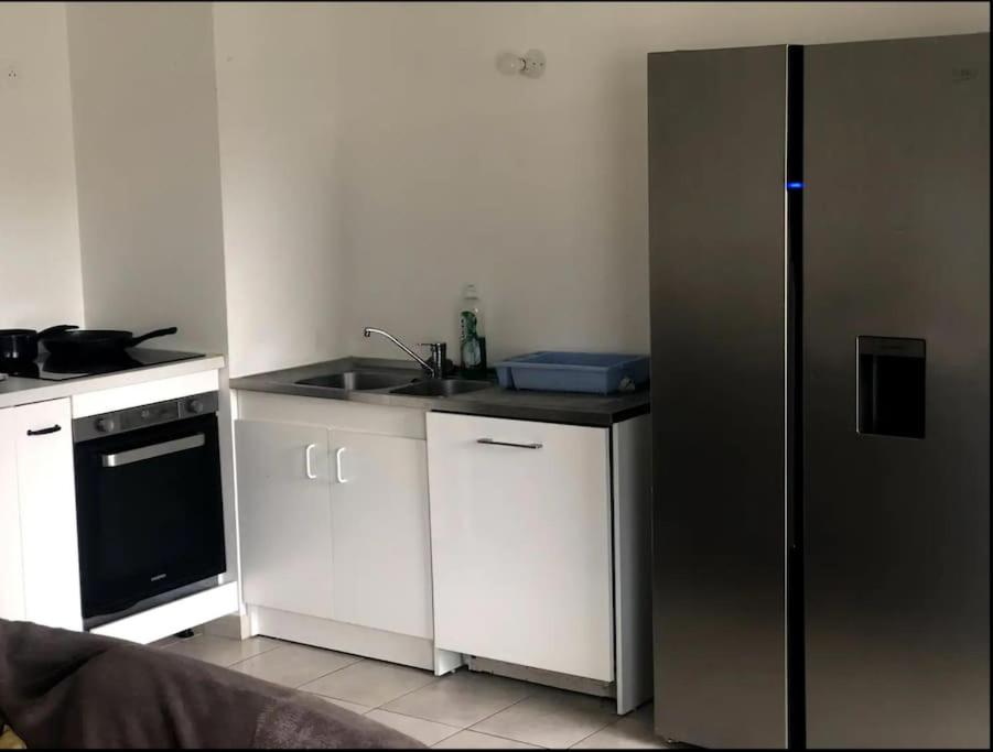 a kitchen with white cabinets and a stainless steel refrigerator at Jolie chambre à Nanterre Préfecture proche La Défense Aréna Campus SNCF et Paris in Nanterre