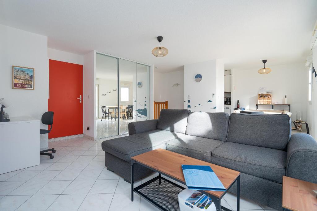 een woonkamer met een bank en een tafel bij Rêve De Mer - Appartement 6 in Frontignan