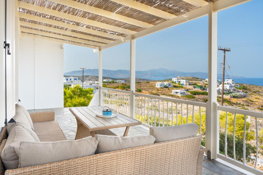 a patio with a couch and a table on a balcony at Gaia Seaview Residence Irakleia in Áyios Yeóryios