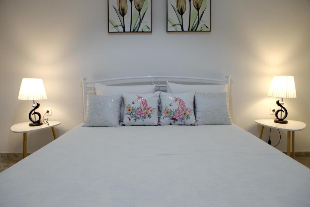 a bedroom with a large white bed with two lamps at Didis Place Nafplio in Nafplio