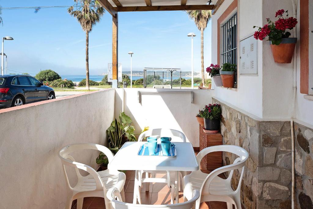 Casa Vistas al Mar Bolonia في تريفة: طاولة وكراسي على فناء مطل على المحيط