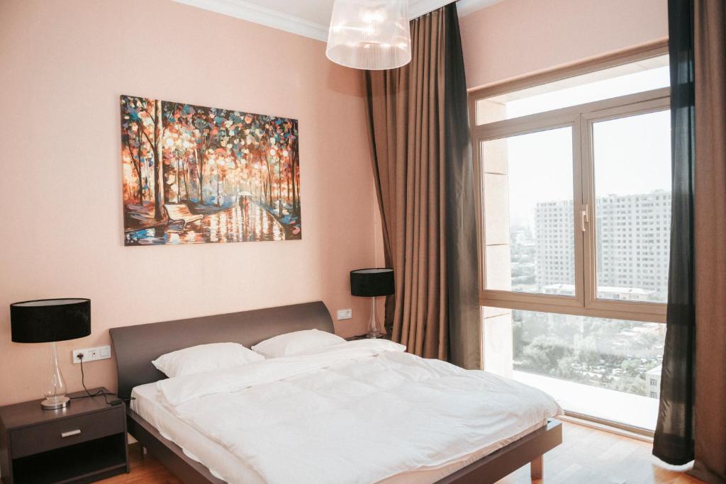 una camera da letto con un letto e un dipinto sul muro di City Center Deluxe Apartments a Baku