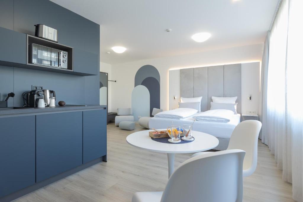 um quarto com uma cama, uma mesa e cadeiras em zzzpace Smart-Hotel Bielefeld Zentrum em Bielefeld