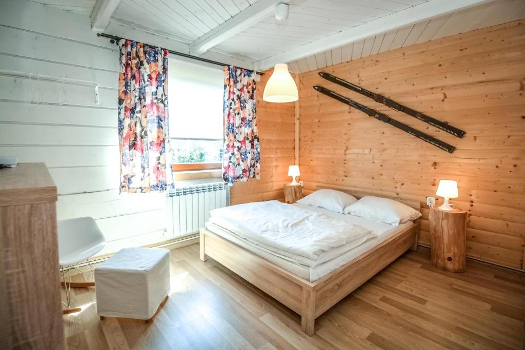 a bedroom with a bed and a wooden wall at Apartament u Gabrysi in Białka Tatrzańska