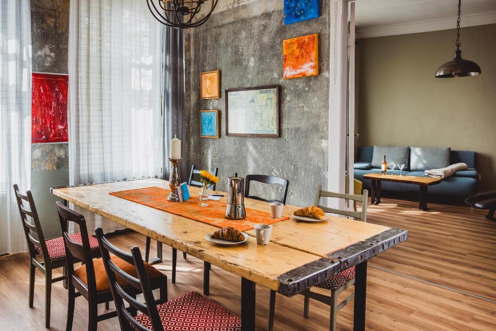 a dining room with a wooden table and chairs at Charmanter Altbau zwischen Altstadt und Klinikum mit Parkplatz in Greifswald