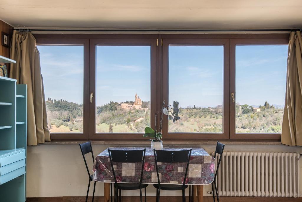 una sala da pranzo con tavolo, sedie e finestre di Casa Ravacciano a Siena