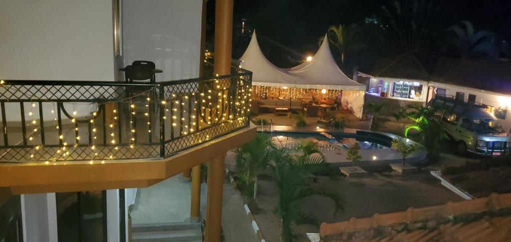 eine Aussicht über einen Balkon mit Beleuchtung und einem Pool in der Unterkunft Mowicribs Hotel and Spa in Entebbe
