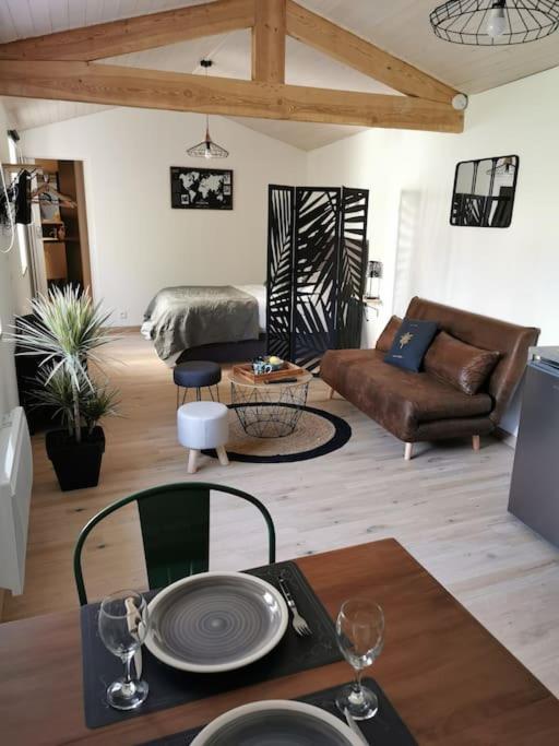 ein Wohnzimmer mit einem Tisch und einem Sofa in der Unterkunft Chaleureux Studio de 35m2 totalement indépendant in Fors