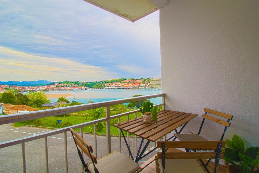 uma varanda com mesa e cadeiras e vista para o oceano em Apartamento Vista Picos em San Vicente de la Barquera