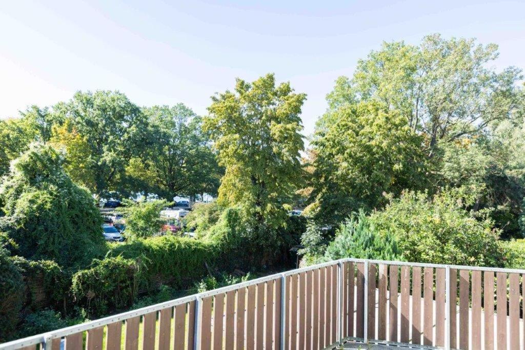 una valla de madera con árboles en el fondo en Perle am Maschsee. Ein Haus mit Garten und 4 Zimmern en Hannover