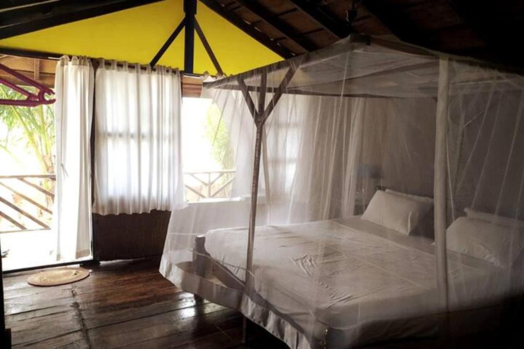 a bedroom with a white bed with a canopy at Neelchand in Canacona