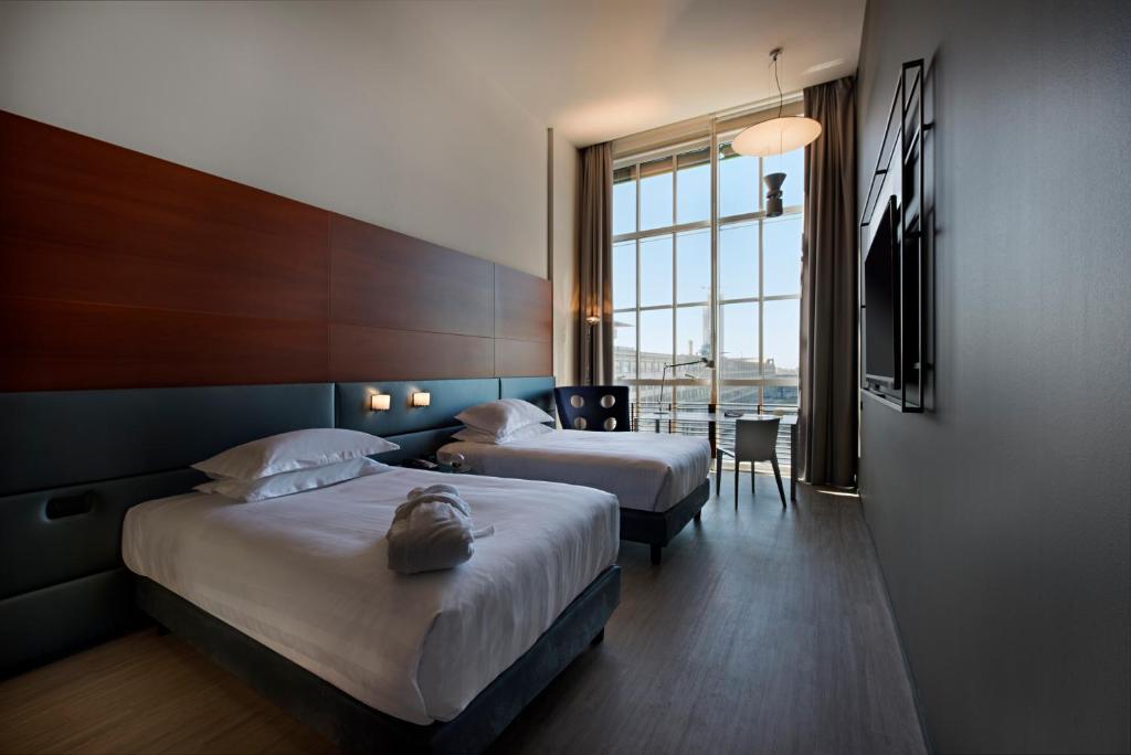 都靈的住宿－都靈靈格托希爾頓逸林酒店，酒店客房设有两张床和窗户。