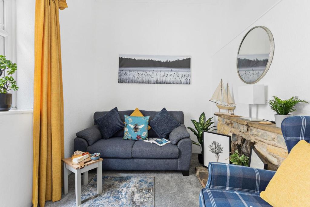 un soggiorno con un divano e uno specchio di The Cottage, Budleigh Salterton a Budleigh Salterton