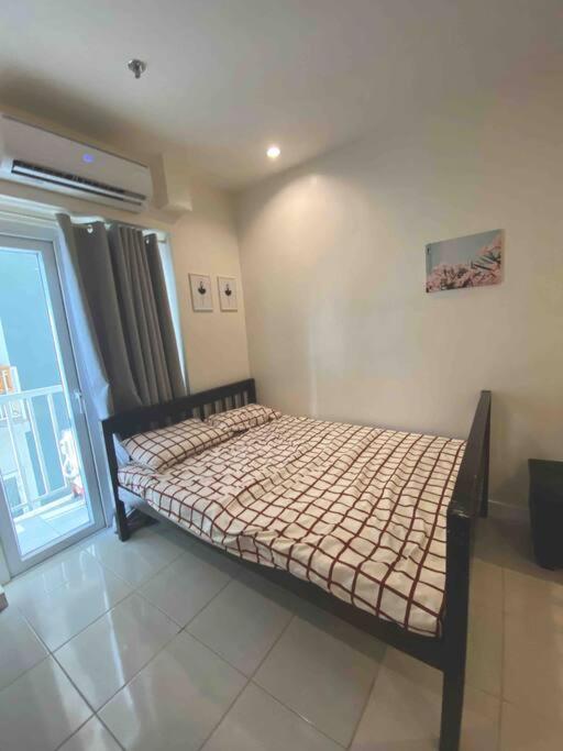 een klein bed in een kamer met een raam bij Condo in Tomas Morato, Quezon City in Manilla
