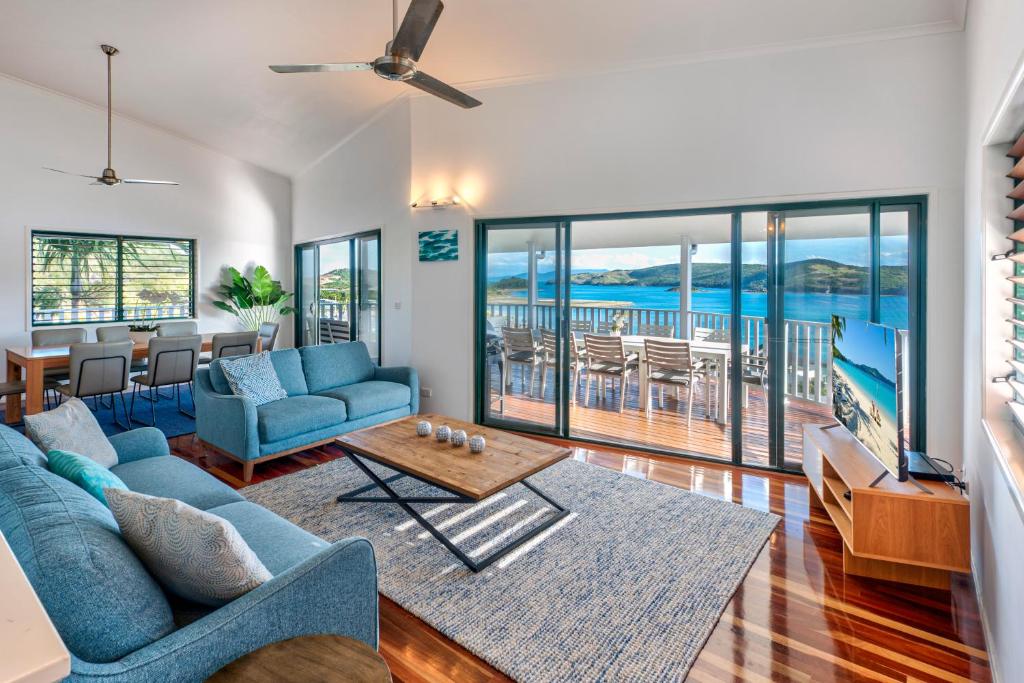 a living room with a blue couch and a table at Casuarina Cove 14 & Buggy - Hamilton Island in Hamilton Island