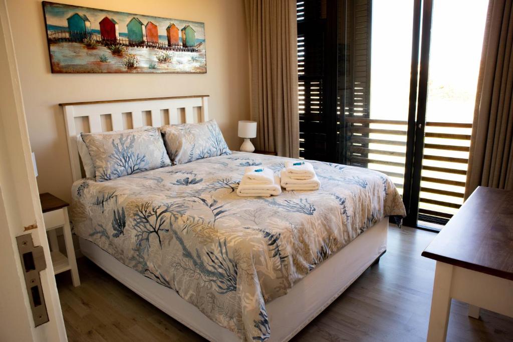 a bedroom with a bed with towels on it at 33D Kabeljauws Beach in Jeffreys Bay