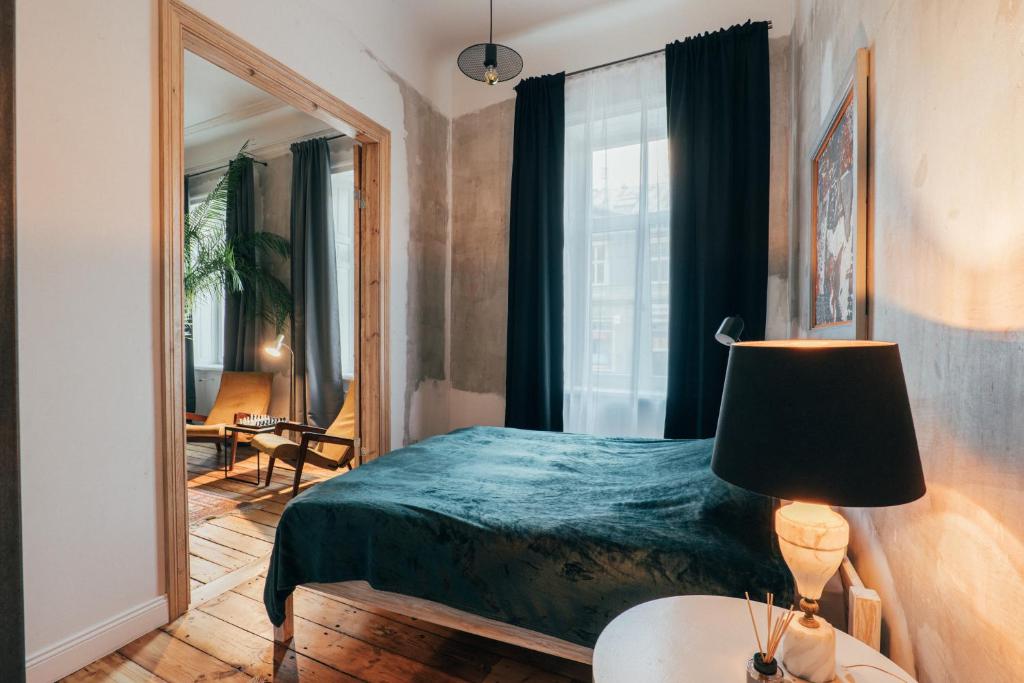 een slaapkamer met een groen bed en een spiegel bij Miller`s place in Rīga