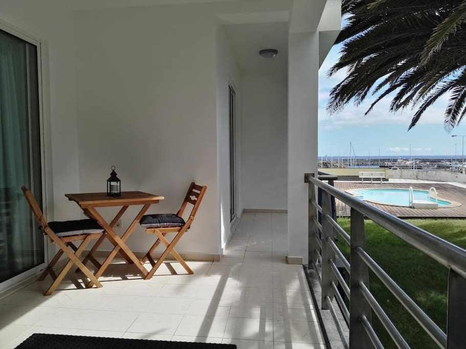 a patio with a table and chairs on a balcony at Marina Mar Vila Franca do Campo in Vila Franca do Campo