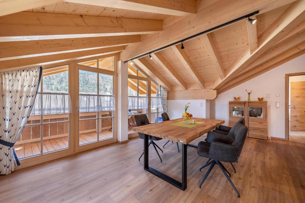 ein Esszimmer mit einem Holztisch und Stühlen in der Unterkunft Ferienwohnung Susi im Neubau in Farchant