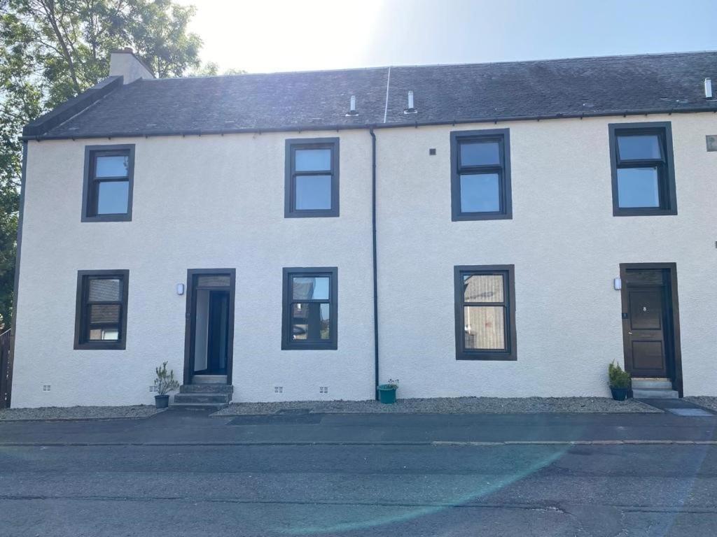 a white house with black windows and doors at Welltrees Apartments 10 Dailly Road in Maybole