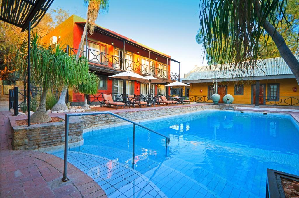 a large swimming pool in front of a house at Auob Country Lodge in Gochas