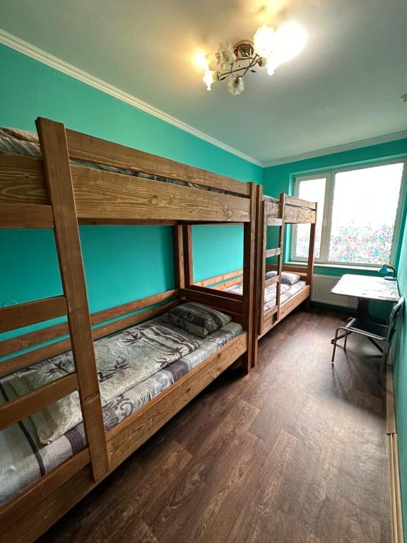 ムカチェヴォにあるWelcome 24 Mukachevoの緑の壁のドミトリールームの二段ベッド2台