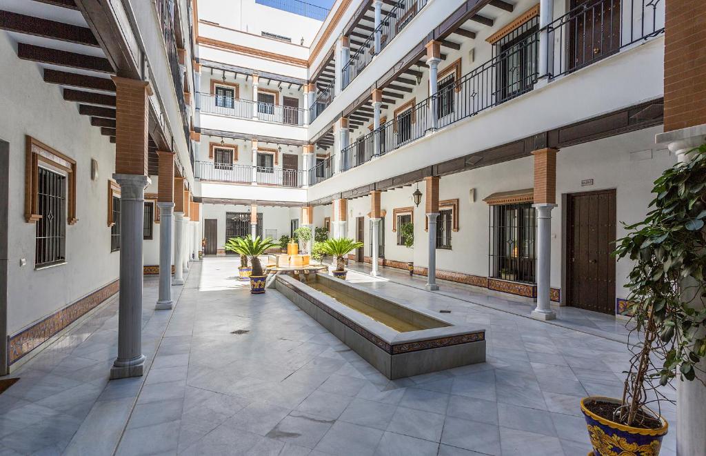 an empty courtyard with a fountain in a building at Santa Catalina Patio Andaluz Moderno in Seville