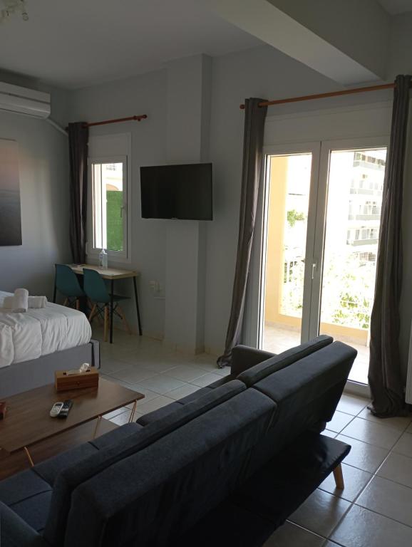 een woonkamer met een bank en een bed bij Gk Suites-Constantin view , auto check-in 24h in Larisa