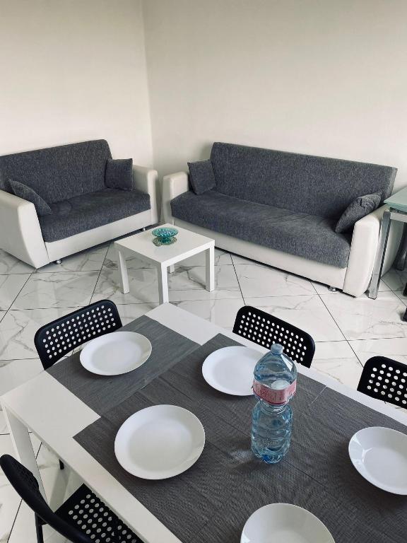 a living room with a table with plates and a bottle of water at Ritiro sul fiume Mantova, Cremona Circuit in Canneto sullʼOglio