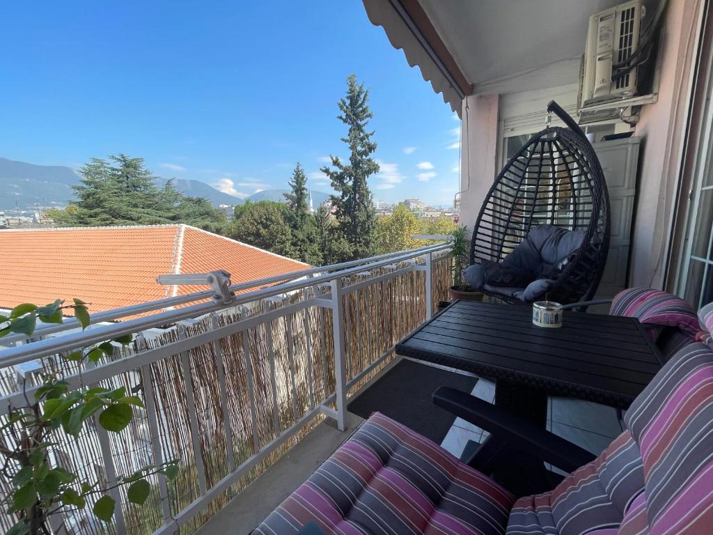 a porch with a table and chairs on a balcony at Pine-Tree Spacious 2 BDR Apartment near Tanners' Bridge with hot tub in Tirana