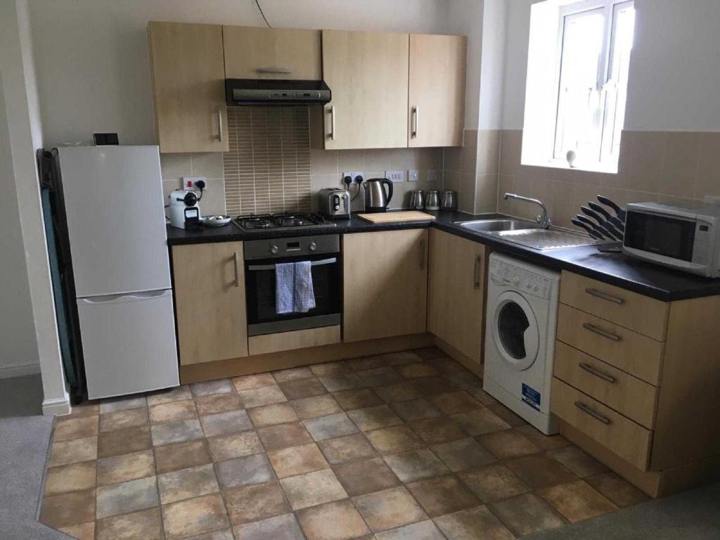a kitchen with a white refrigerator and a dishwasher at K Suites - Teeswater - FREE PARKING in Bridgwater