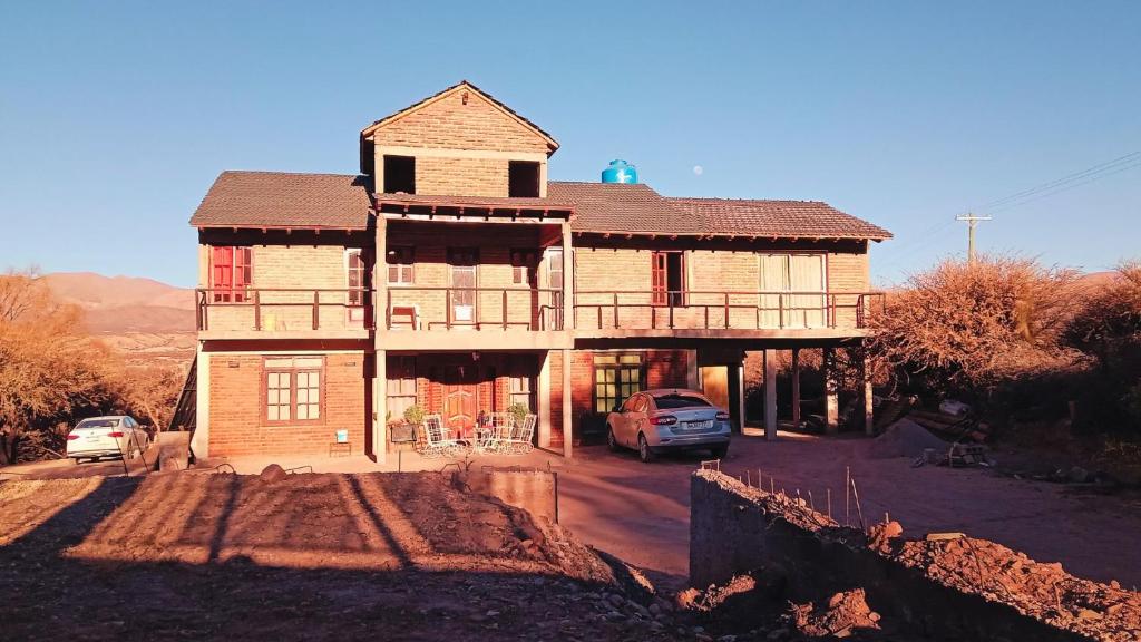 a large house with cars parked in front of it at Paso del Campo Estrellado in Humahuaca