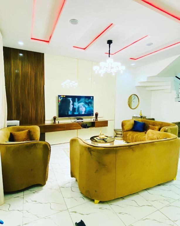 uma sala de estar com dois sofás e uma televisão em FayFays Edifice C1 A Luxury 4 Bedroom Terrace Duplex em Lekki