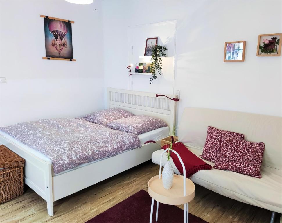 Un dormitorio pequeño con una cama y un sofá. en Apartment mit Garten, 10 min zu Fuß in die Koblenzer Altstadt, en Coblenza