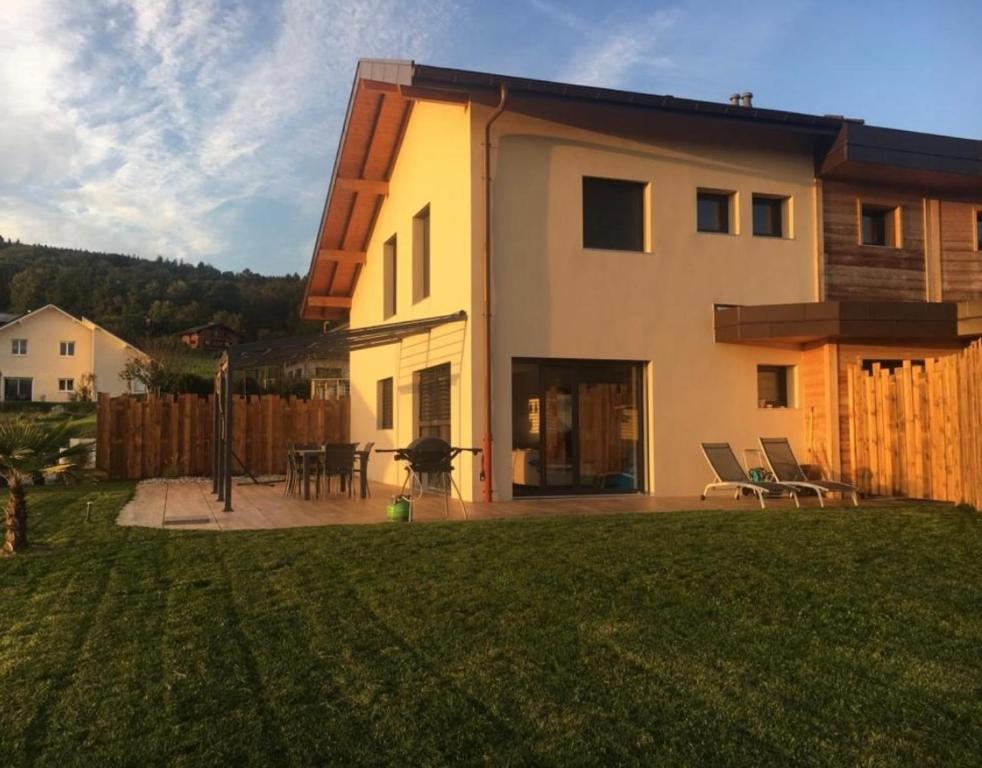 a house with a yard with a patio and a house at Belle maison avec jardin et vue montagne in Epagny Metz-Tessy