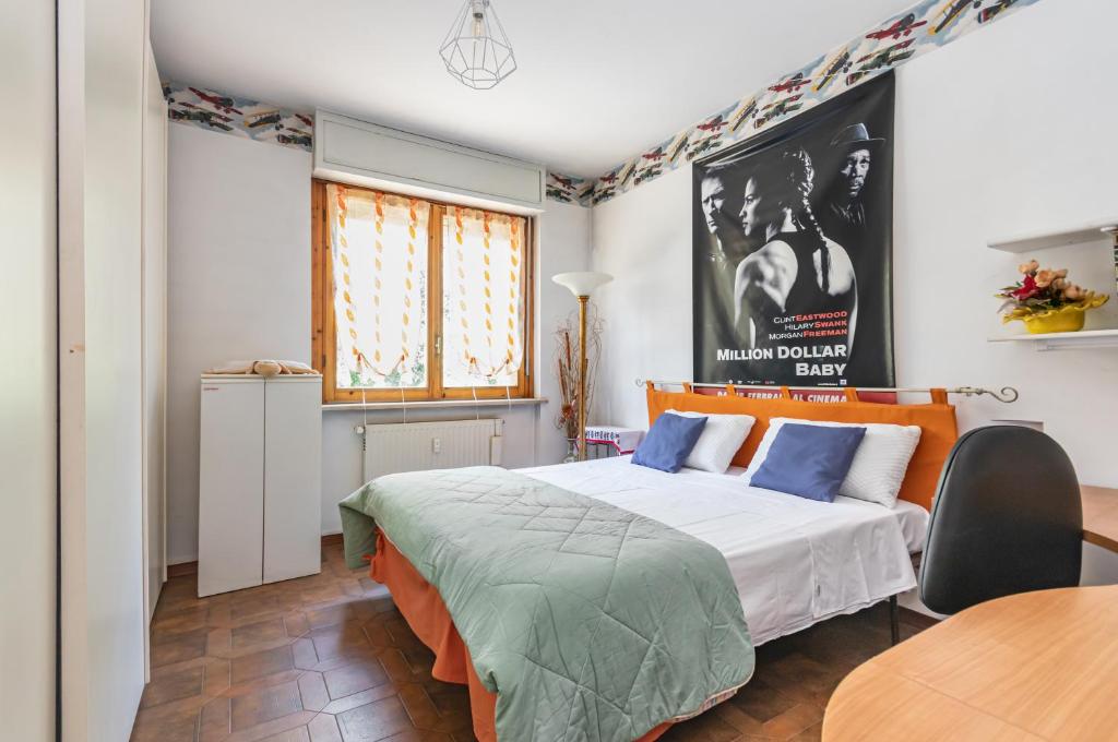a bedroom with a bed and a poster on the wall at Asti Lovely Apt - Private Parking & Balconies in Asti
