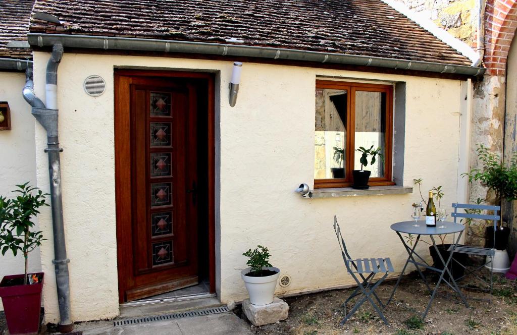 une petite maison avec une porte rouge et une table dans l'établissement La Grange de Misy, à Misy-sur-Yonne