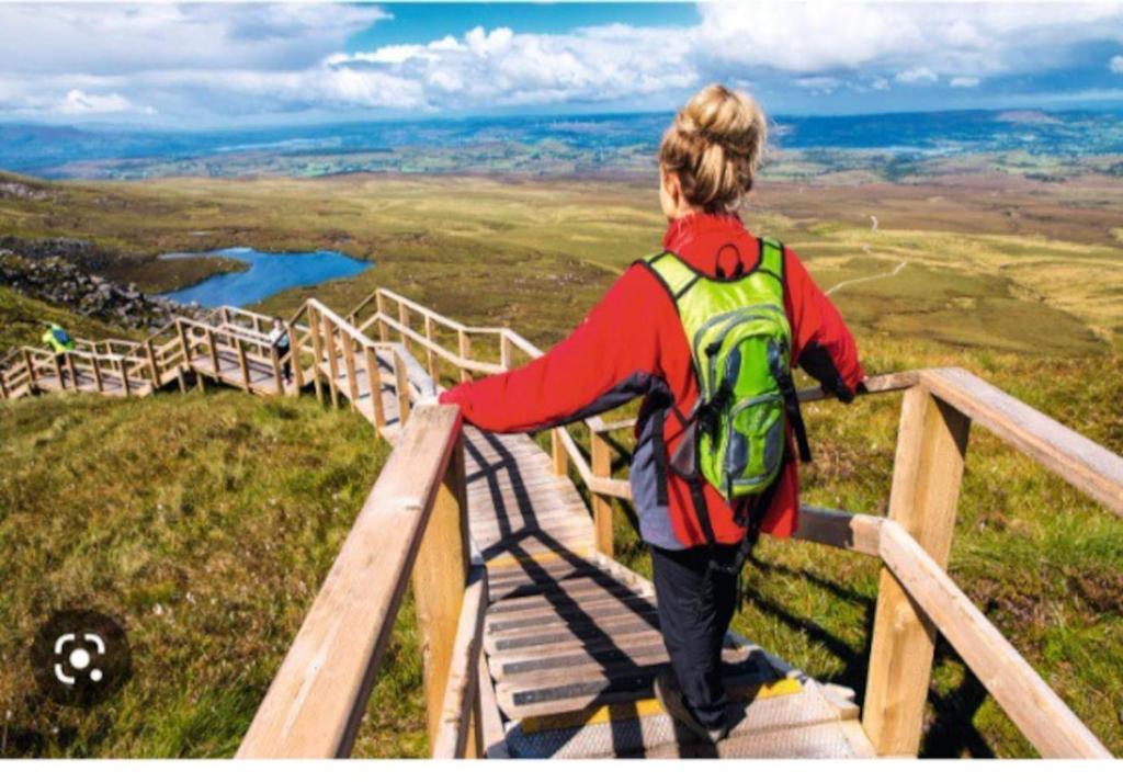 a person with a backpack standing on top of a hill at Lakeland Lodge in Derrylin
