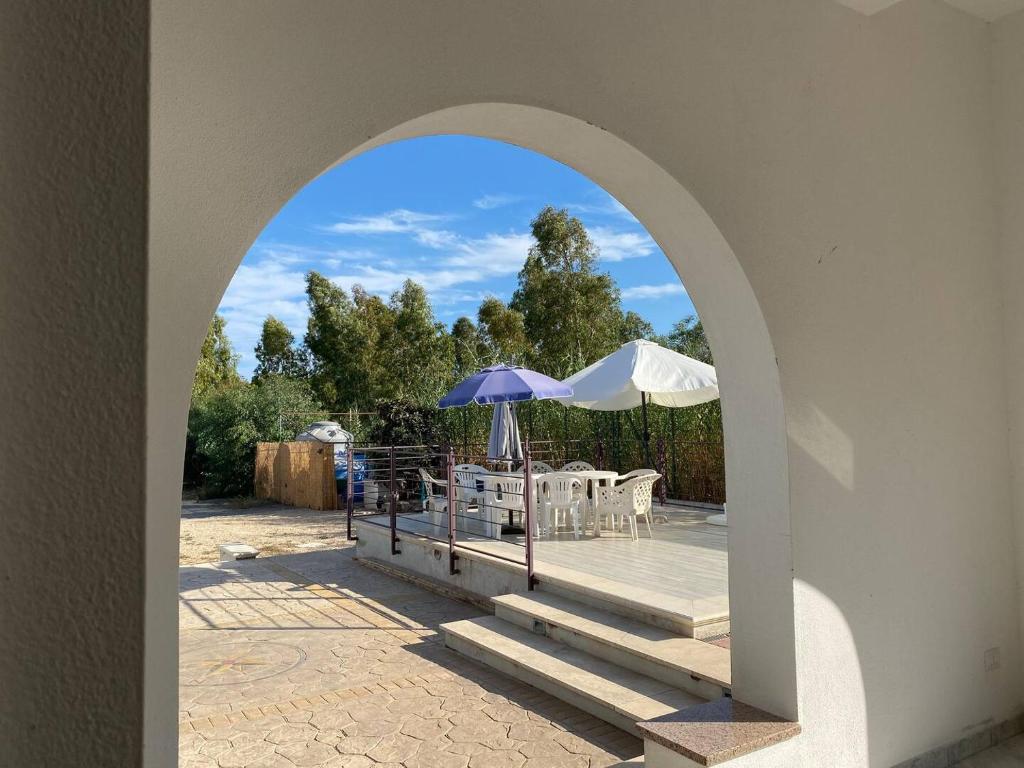an archway with an outdoor table with an umbrella at Edeler House in Pula