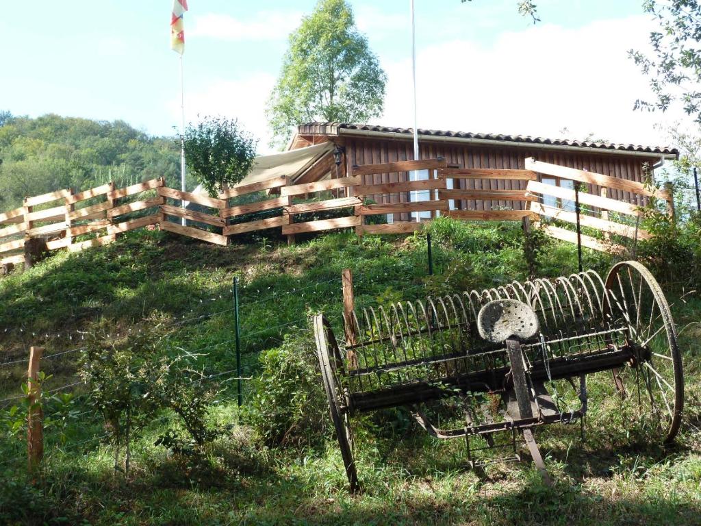 un banco sentado en el césped frente a un edificio en Gîte la Lanterne transition écologique avec borne de recharge 7kw Site sous vidéo protection, en Nalzen