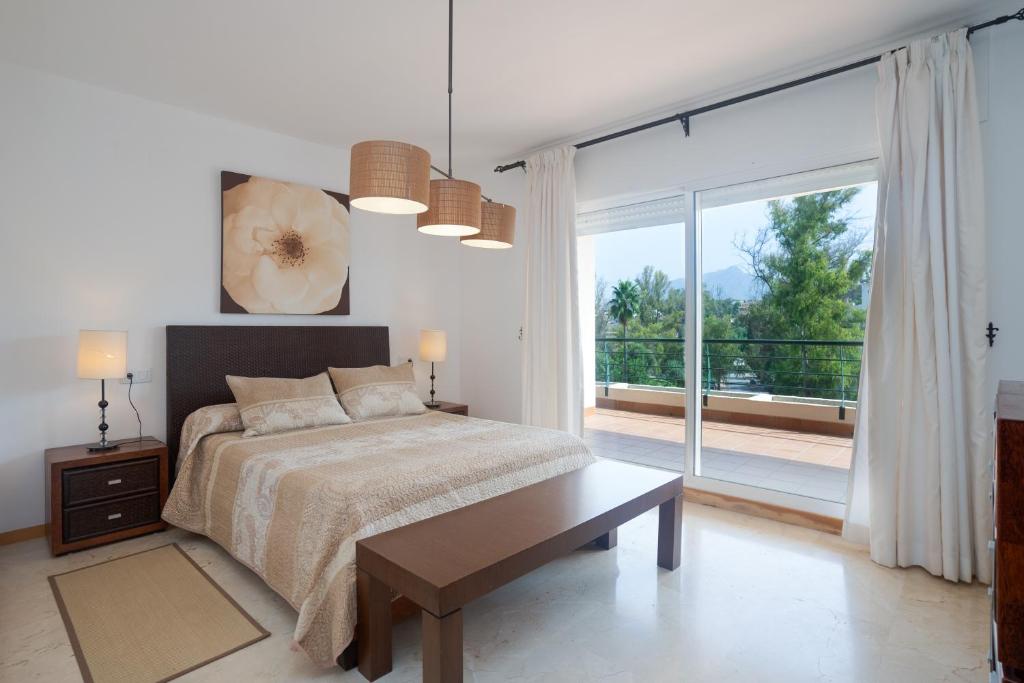 a bedroom with a bed and a large window at Guadalmina Alta in Marbella