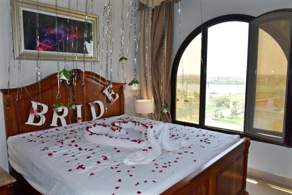 a bedroom with a bed with rose petals on it at Holy Family Hotel in Jabal aţ Ţayr