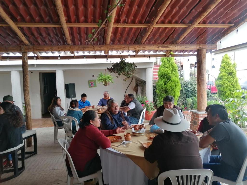eine Gruppe von Menschen, die an einem Tisch in einem Restaurant sitzen in der Unterkunft Hotel Posada El Camino in Chignahuapan